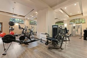Ein geräumiger Fitnessraum mit Cardiogeräten, Krafttrainingsgeräten und Übungsbällen.