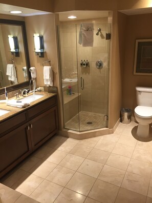 Ein modernes Badezimmer mit einer gläsernen Duschkabine, einem Waschbecken mit Waschtisch und einer Toilette.