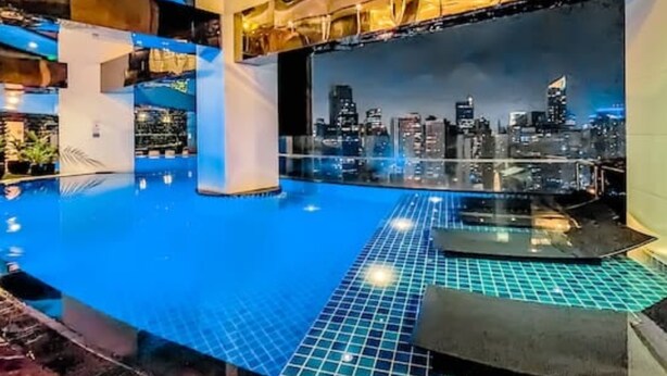 A rooftop infinity pool with a city skyline view. - STAYLUXIA Gramercy 2BR Junior Suite w/Balcony Free Pool Gym Netflix & Amenities  (Makati)