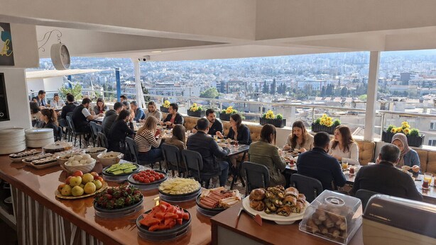 A rooftop dining area with a city view, tables with food, and a bar counter. - Hotel Efesian B&B City Center - Harbour (Kuşadası)