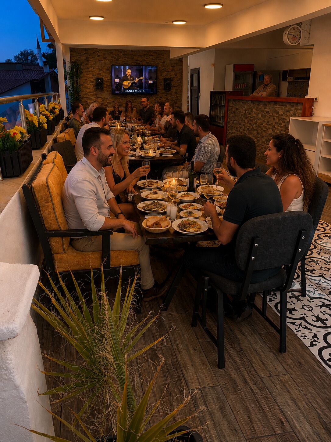 A restaurant with outdoor seating, a television screen, and a clock on the wall.