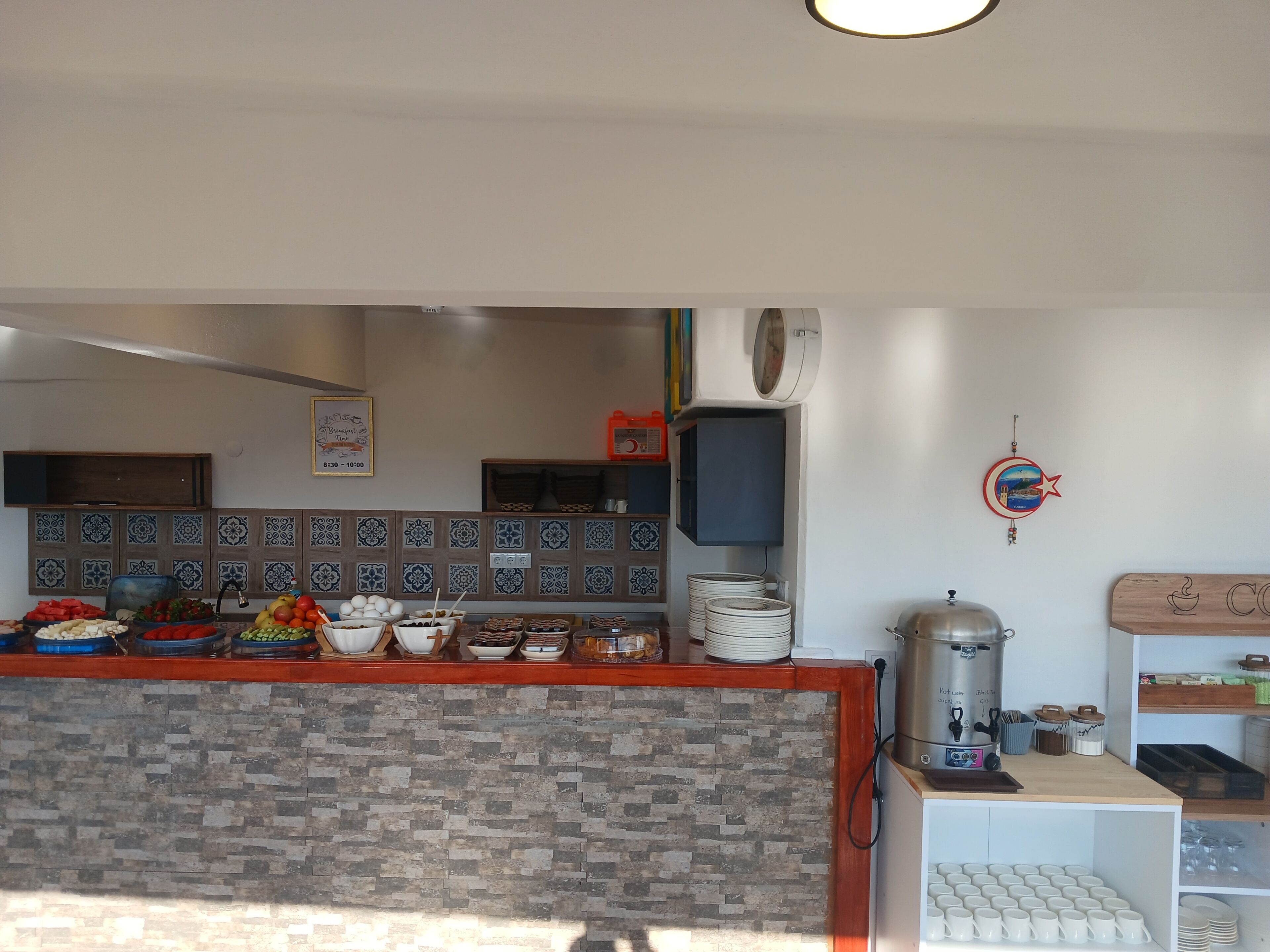 A kitchen area with a tiled backsplash, a coffee machine, and various food items on the counter.