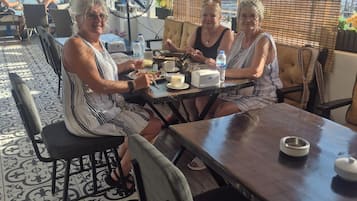 An outdoor seating area with a table, chairs, and a fan.