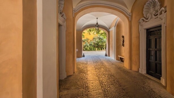 A corridor with arches, a chandelier, and a door. - Pantheon- Finely renovated and furnished apartment 60 sqm 4 beds (Roma)