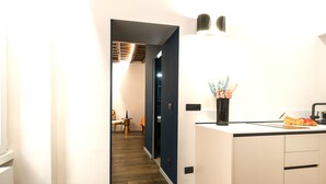 A modern kitchen with white cabinets, a dark wooden floor, and a countertop with a vase of flowers. - Pantheon- Finely renovated and furnished apartment 60 sqm 4 beds (Roma)