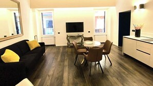 A compact living space with a dining area, a sofa, a TV, and a kitchenette. - Pantheon- Finely renovated and furnished apartment 60 sqm 4 beds (Roma)