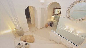 A modern interior with a staircase, a mirror, and a seating area with cushions. - Piazza Navona Hydromassage Tub 7 people (Rome)
