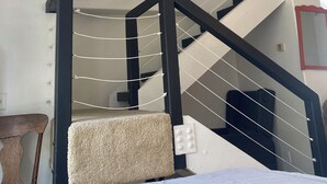 Un interior moderno con una escalera, una cama y un rascador para gatos.