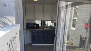 Un patio con una puerta de vidrio que da a una zona de cocina.