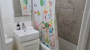 A bathroom with a white sink, toilet, and bathtub.