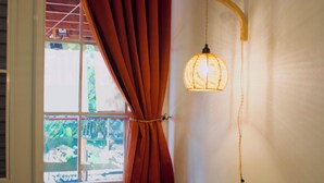 A room with a wooden table and bench, a window with a view of greenery, and a hanging lamp. - Private Finca Ki' •3BR • Hammock Terrace • El Yunque • Ceiba Ferry • Easy-Access (NAGUABO)