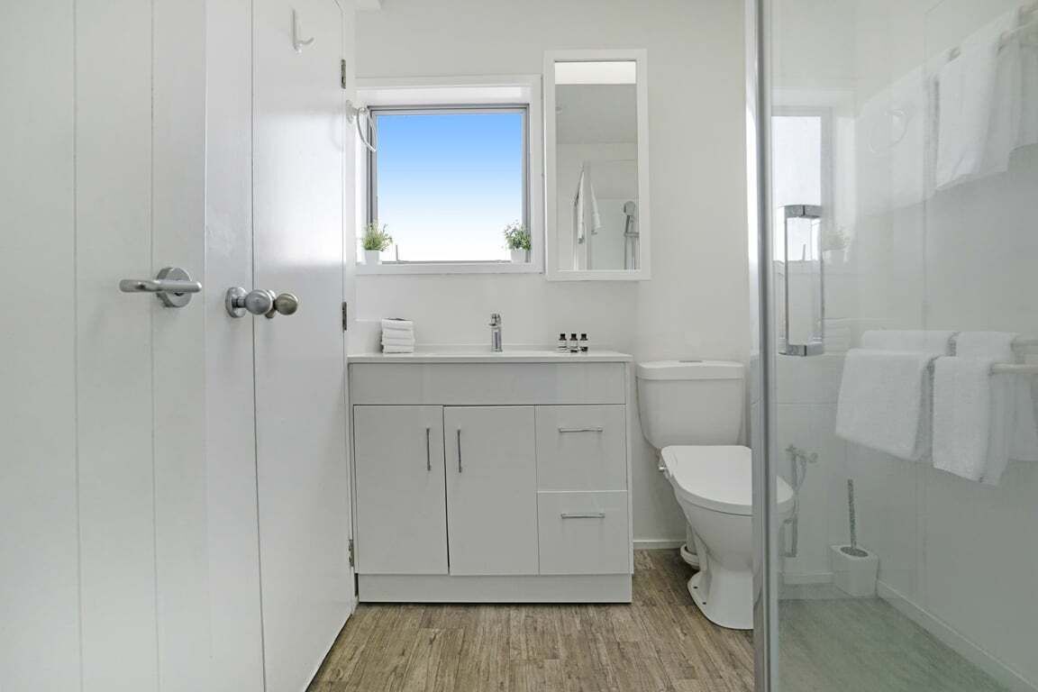 A modern bathroom with a toilet, sink, and shower area.