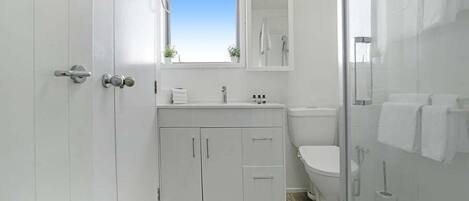 A modern bathroom with a toilet, sink, and shower area.