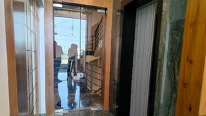 A hallway with a glass door leading to a staircase. - Heaven X Inn Hotel (Indore)