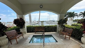 A covered outdoor area with a pool, benches, and potted plants. - Water View with Balcony- newly renovated Contemporary style (Lantana)