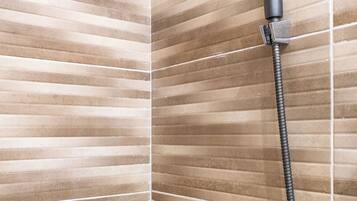 A shower with a handheld showerhead and a flexible hose.