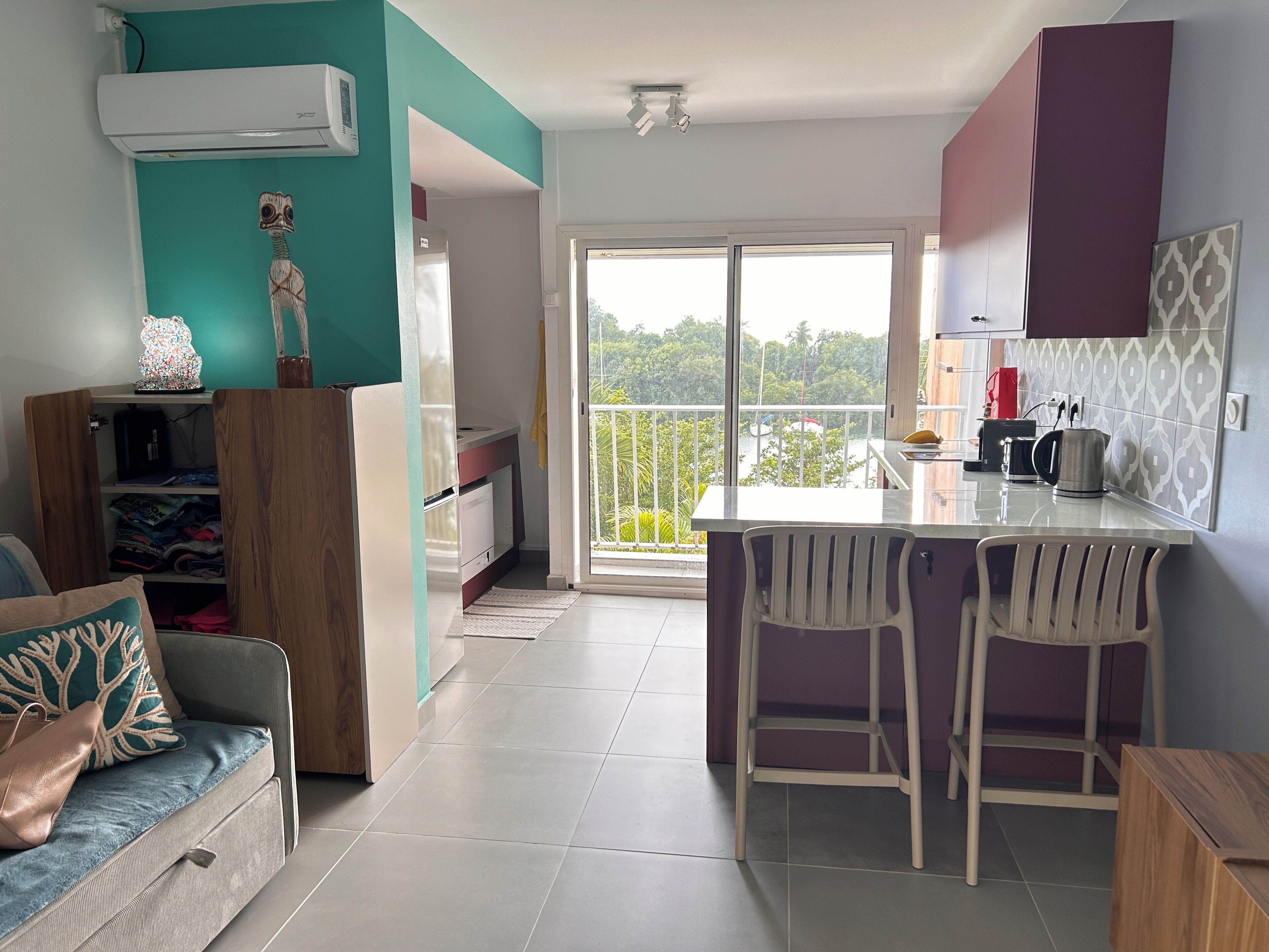 Cozinha moderna com área de bar, mesa de jantar e vista para o exterior.