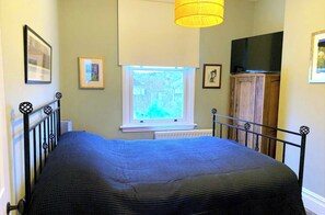 A bedroom with a bed, a window, a television, and a cabinet. - Perfect 3-bedroom Edwardian town house in Bath for a home from home getaway (Bath)