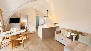 Un espace de vie compact comprenant un coin repas, une kitchenette et un canapé.
