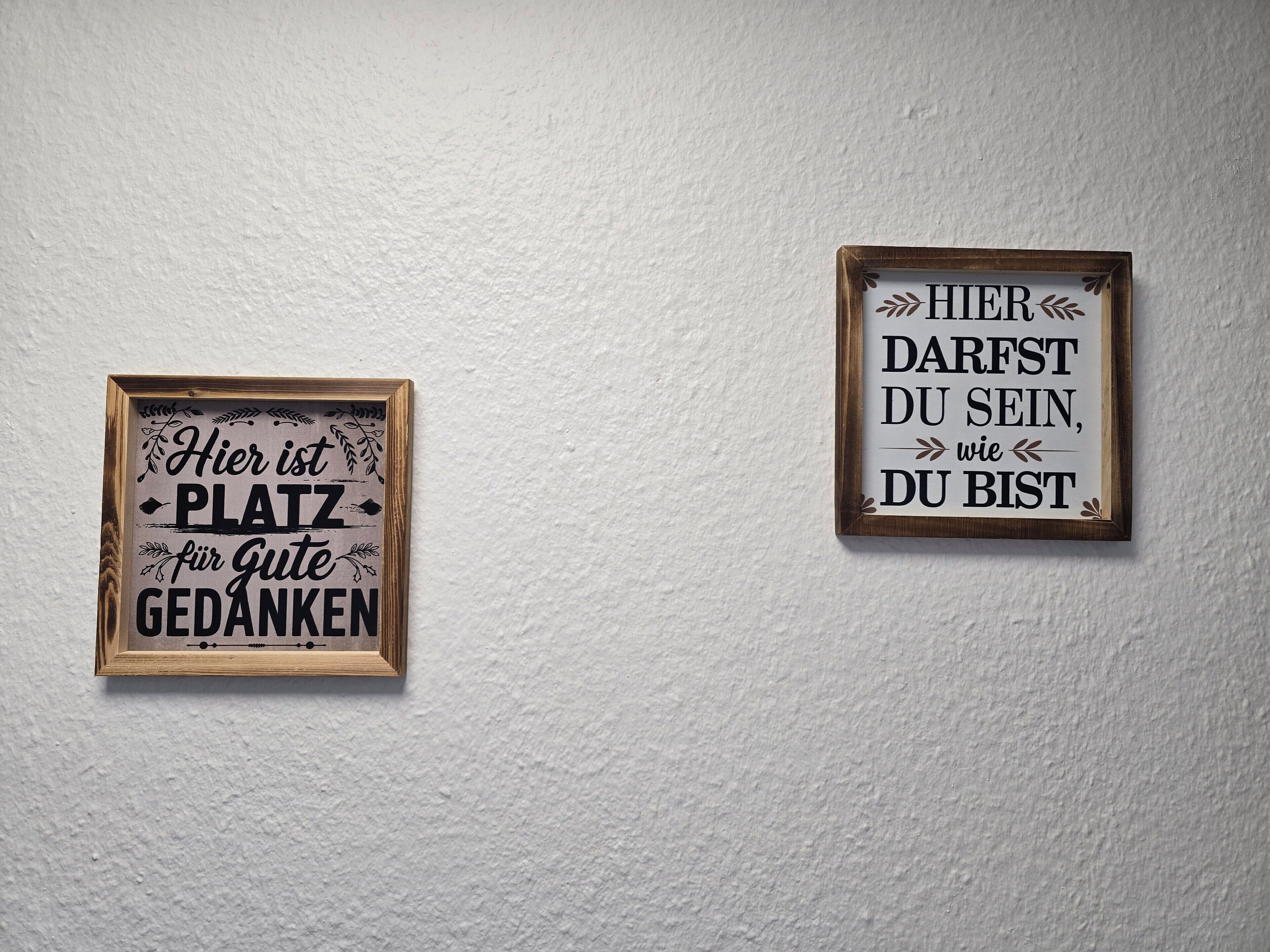 Two framed signs on a wall.