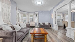 Un salon spacieux avec une grande table basse en bois, un canapé gris et un fauteuil gris.