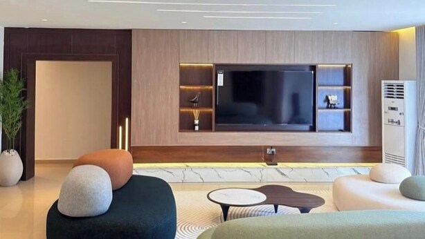 A modern living room with a large flat-screen TV, comfortable seating, and a minimalist design. - Asokoro Luxury Apartment (Abuja)