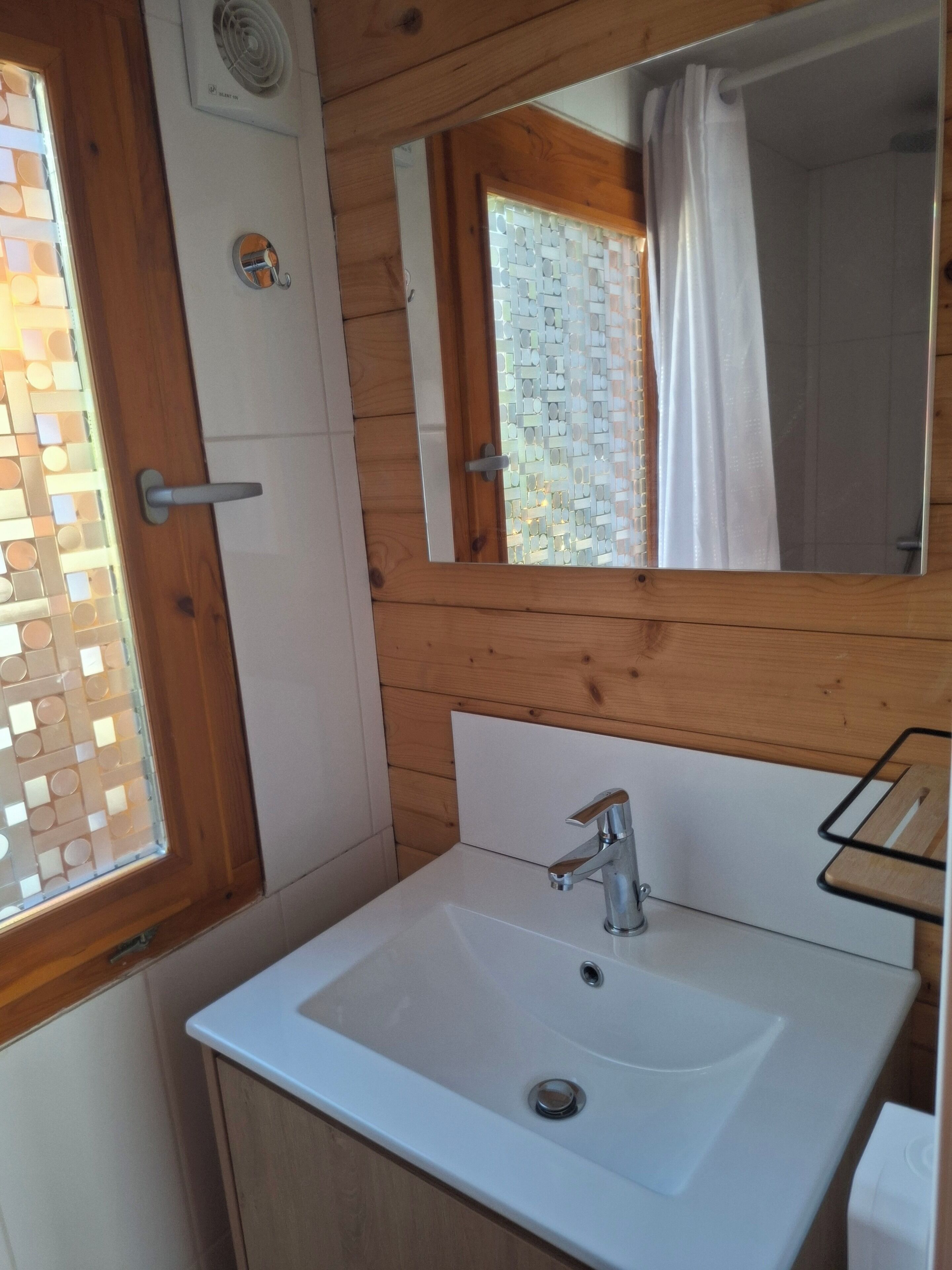 A bathroom with a white sink, a mirror, and a wooden door.