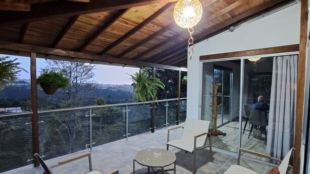 A covered patio with a wooden ceiling, a hanging light fixture, and a view of a mountainous landscape. - Spacious house with 360° view of coffee plantations - Filandia (Filandia)