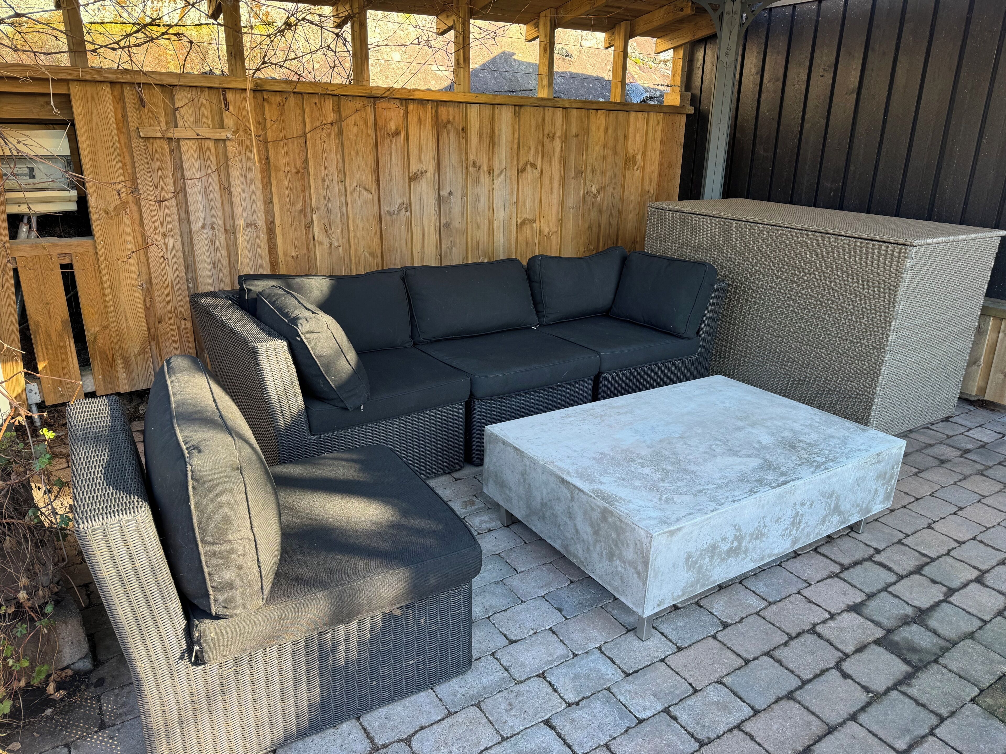 A patio with a sectional sofa, a chaise, and a coffee table.