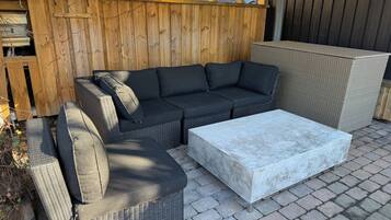 A patio with a sectional sofa, a chaise, and a coffee table.
