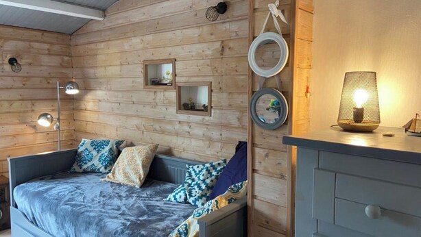 Una habitación acogedora con cama, lámparas de noche y cómoda.