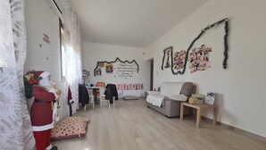Tilava olohuone, jossa on sohva, sohvapöytä ja joulukoristeita.
