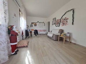 A spacious living room with a sofa, a coffee table, and a Christmas decoration. - Independent Villa in Alcamo for real Pet Lovers, large garden space and relaxation (Alcamo)
