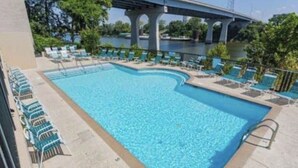 Ein Schwimmbecken mit Liegestühlen und einer Brücke im Hintergrund.