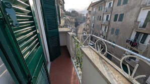 A narrow balcony with a metal railing overlooking a street with buildings. - La Mola B&B - a stone's throw from Viterbo and Rome (Vignanello)