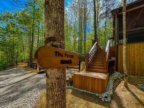 A wooden signpost with 'The Perch' written on it, a staircase leading to a wooden building, and a gravel path. - Hot Tub Cabin + Screened Porch | Red River Gorge (Beattyville)