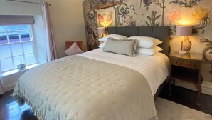 A bedroom with a large bed, a decorative wall mural, and two bedside lamps. - Quaint Irish Cottage in the very heart of Kinsale Town (Kinsale)