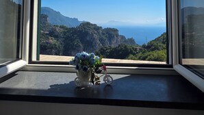 A window with a view of a mountainous landscape and the sea. - GREEN NEST with a sea view (Amalfi)