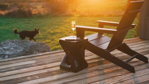 A wooden deck with a chair and a glass of champagne. A dog is visible in the background. - Charming 2-bedroom house in Sea Ranch perfect for relaxing getaway (Sea Ranch)