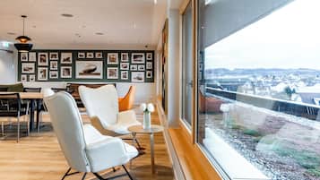 A modern interior with a dining area, seating, and a large window with a view.
