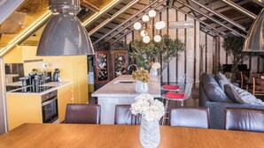Een moderne keuken met een eethoek, een bank en een vaas met bloemen op tafel.