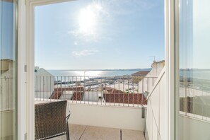 Ein Balkon mit Blick auf das Meer und Gebäude.