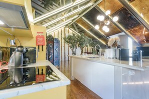 A modern kitchen with a marble countertop, stainless steel appliances, and a wooden floor. - Luxury Loft in Alfama with Balcony and River View (Lisboa)