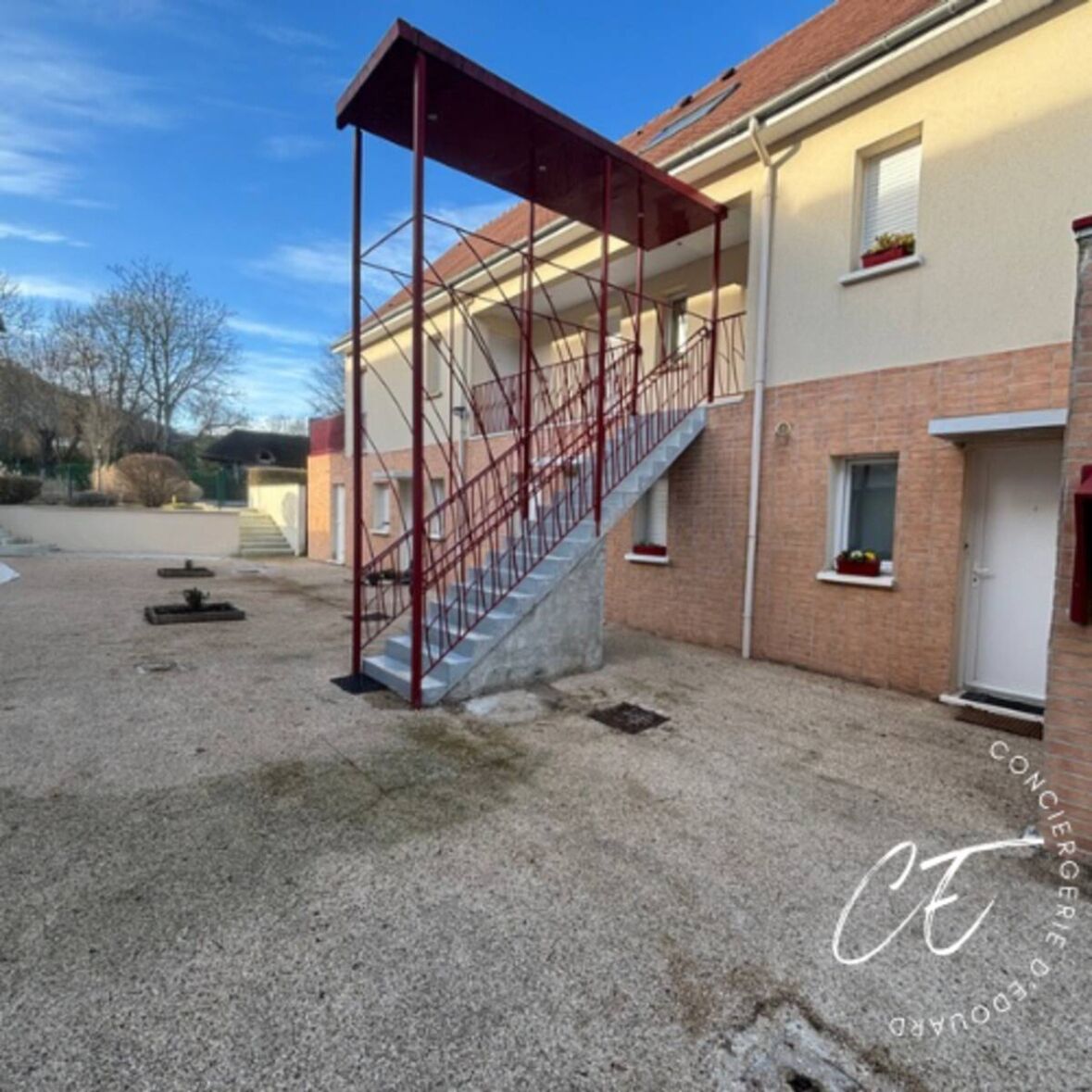 Un bâtiment doté d’un escalier extérieur abrité qui mène au deuxième étage.