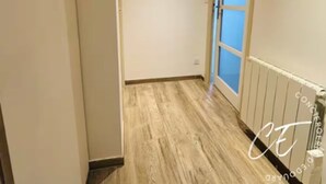 A narrow hallway with wooden flooring, a door with a blue glass panel, and a wall-mounted decorative mirror. - Duplex 6 persons with 2 parking spaces - Honfleur (Honfleur)