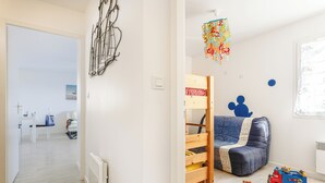 A child's room with a bed, toys, and a hanging decoration.