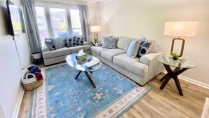 A living room with two sofas, a coffee table, a TV, and a lamp.