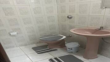 Chuveiro, toalhas de banho, papel higiênico