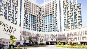 A modern high-rise building with multiple balconies and a large entrance area. - Modern Deluxe Studio in Dubai (Al Jaddaf)