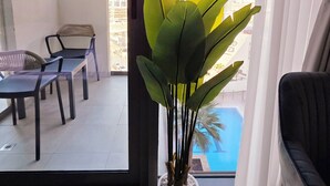 A balcony with a view of a construction site, a potted plant, and a sofa. - Modern Deluxe Studio in Dubai (Al Jaddaf)